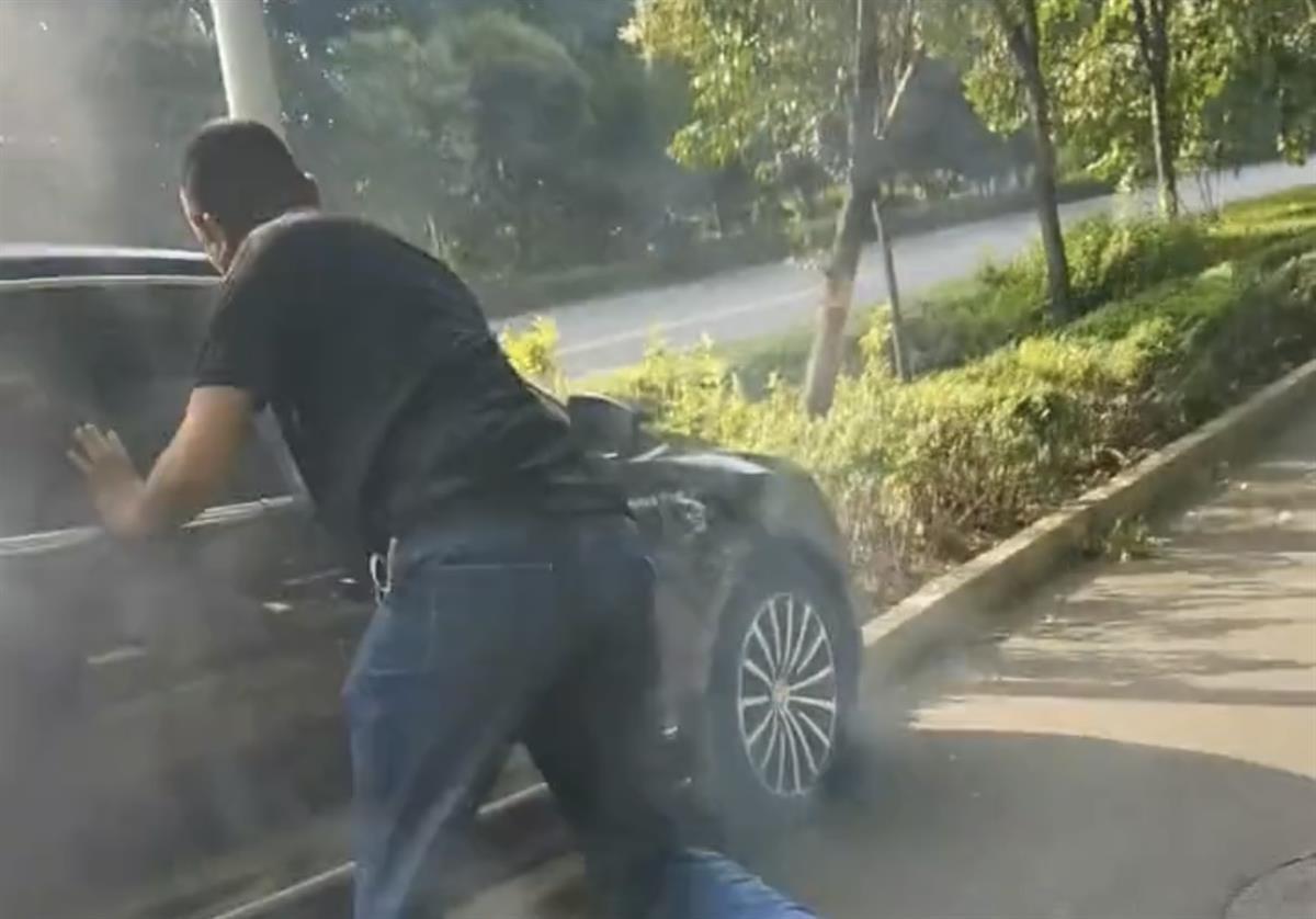 惊火狐电竞险！轿车撞绿化带司机昏迷被困路人砸窗将其拖出一分钟后车辆起大火(图1)